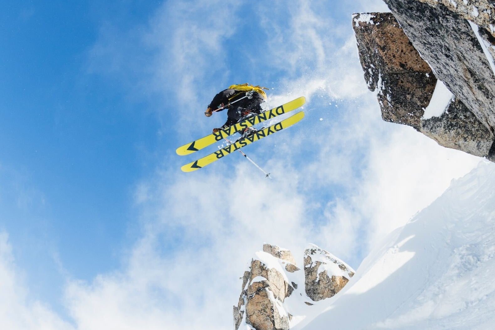 skier jumping off a cliff in the backcountry